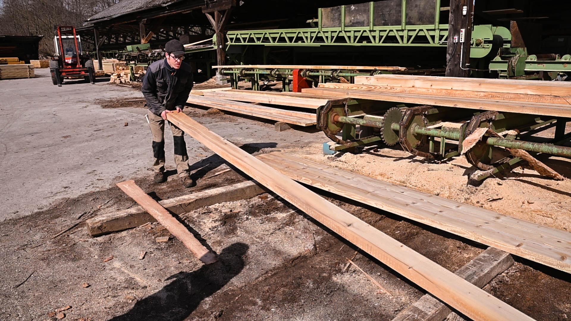 Un employé de la scierie empile du bois de charpente